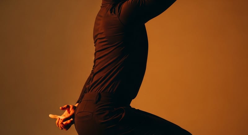 Cinematic editorial photograph of an anonymous adult mid-golf-swing, side profile showing thoracic rotation, warm honey-gold side-lighting against deep espresso brown background